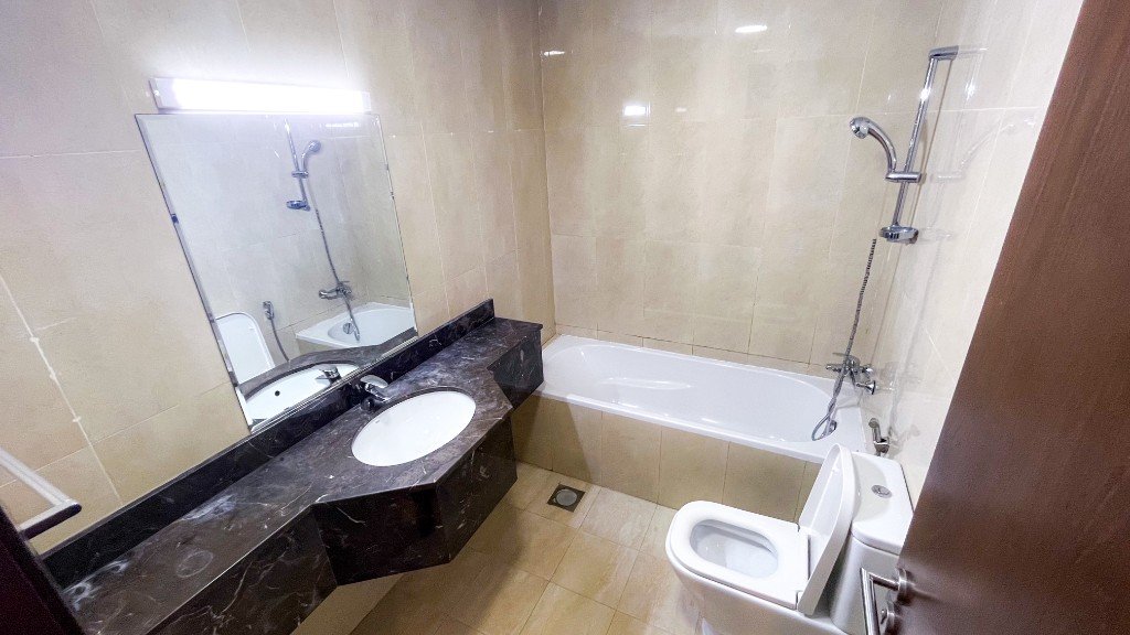 Second bathroom with a bathtub and marble vanity in Azizi Freesia